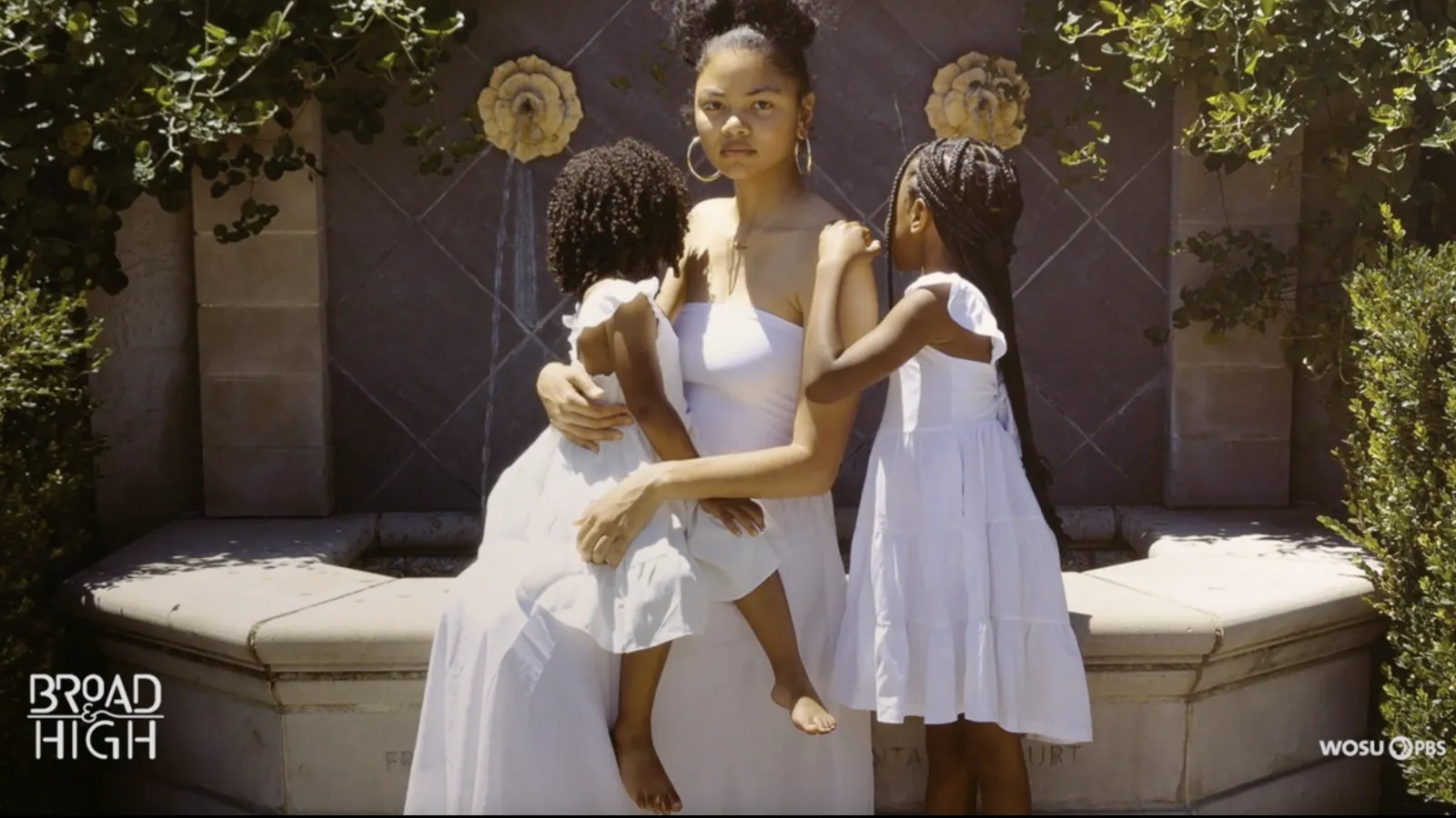 Iyana Hill in a white dress with two young Black girls in white dresses