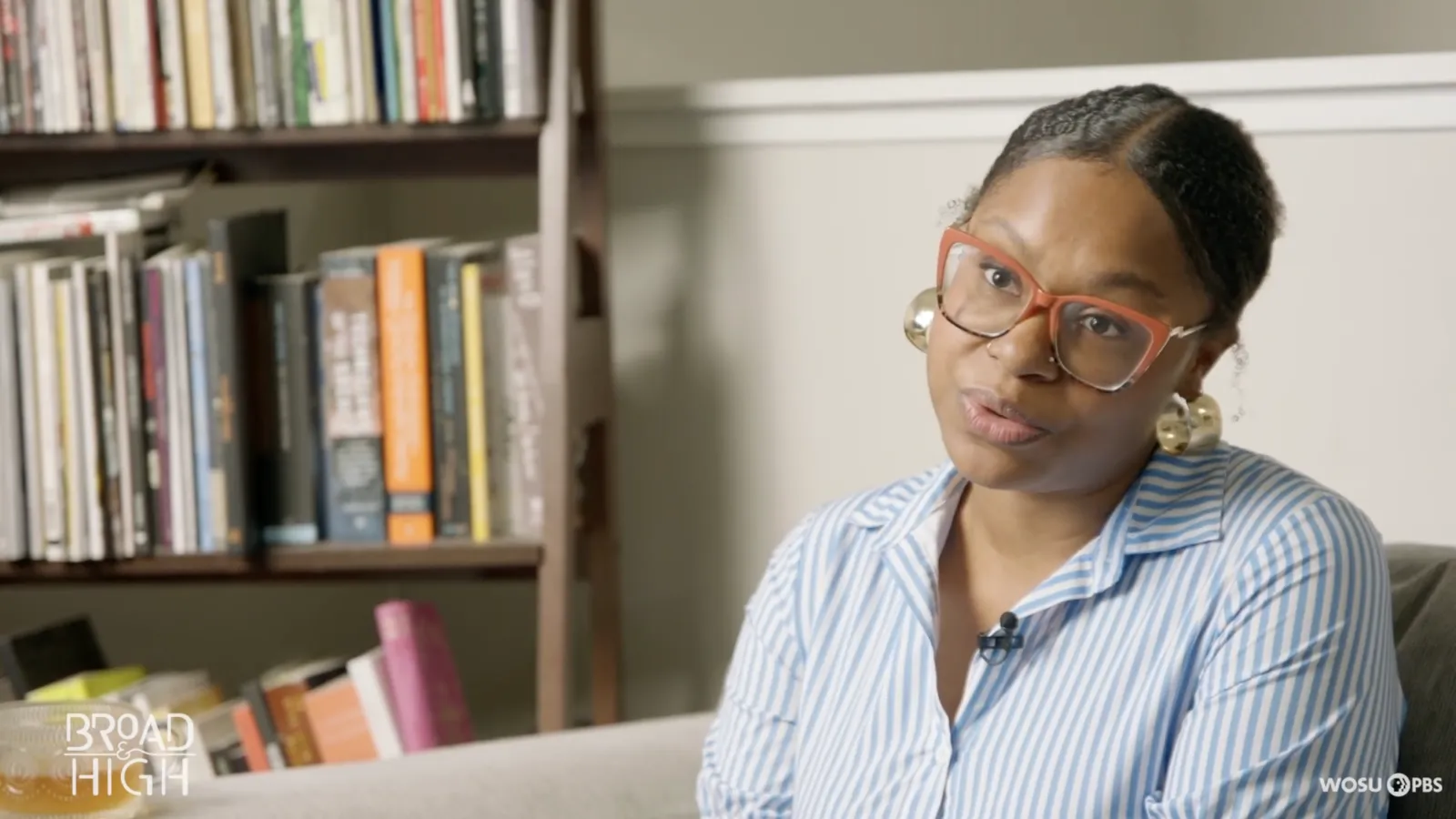 Ajanae Dawkins in glasses being interviewed in her home library