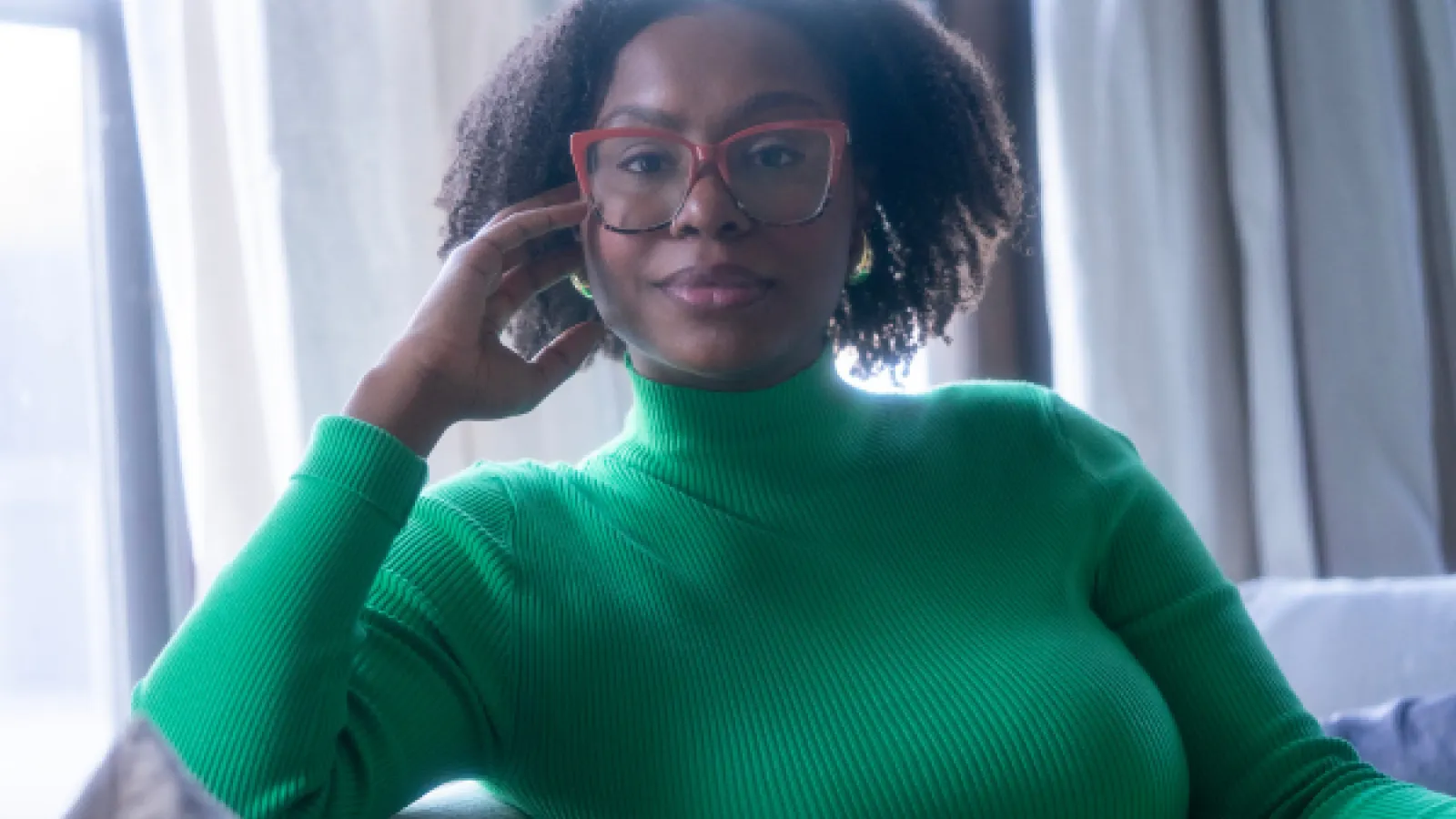 Ajanae in a green sweater smiling
