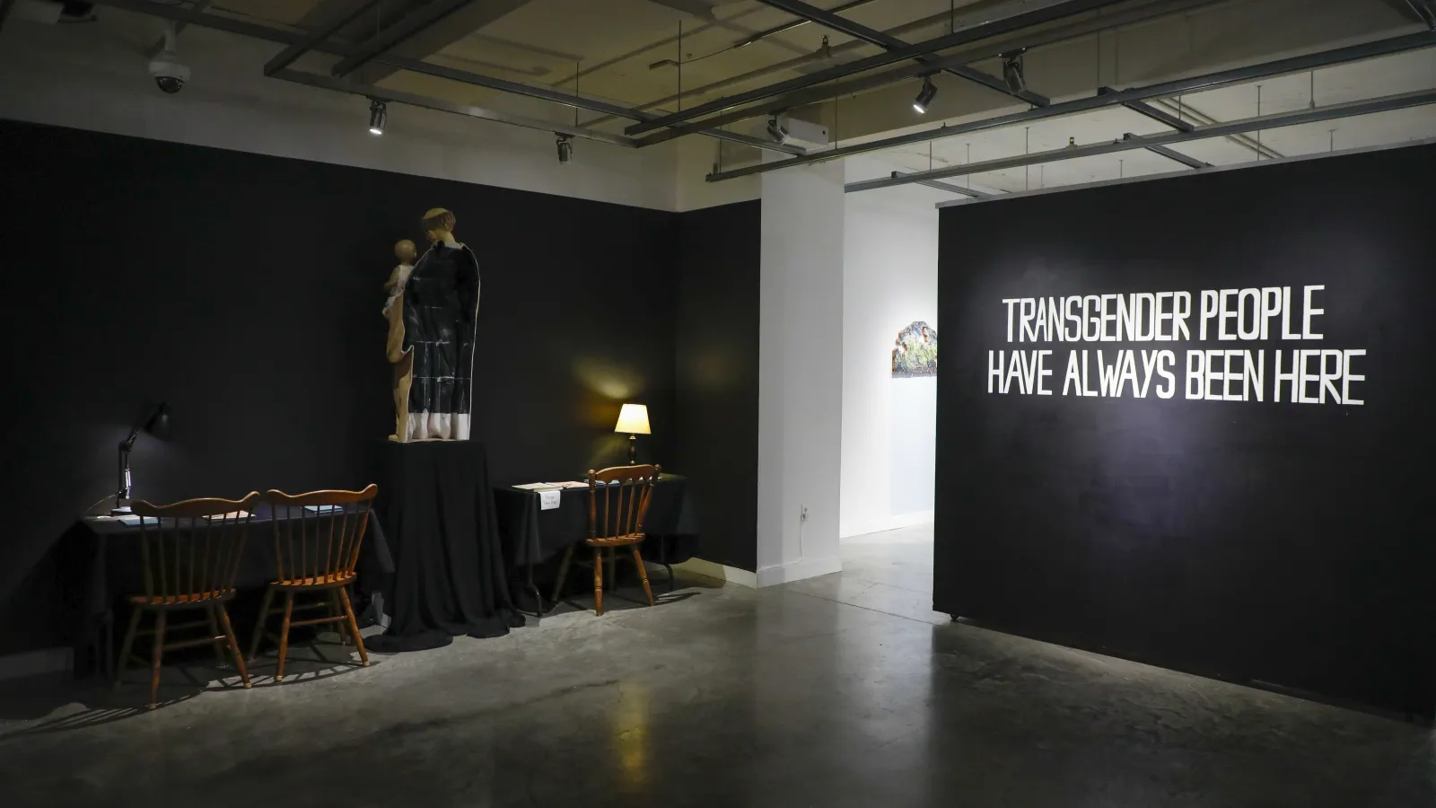 wall painted black with the words transgender people have always been here