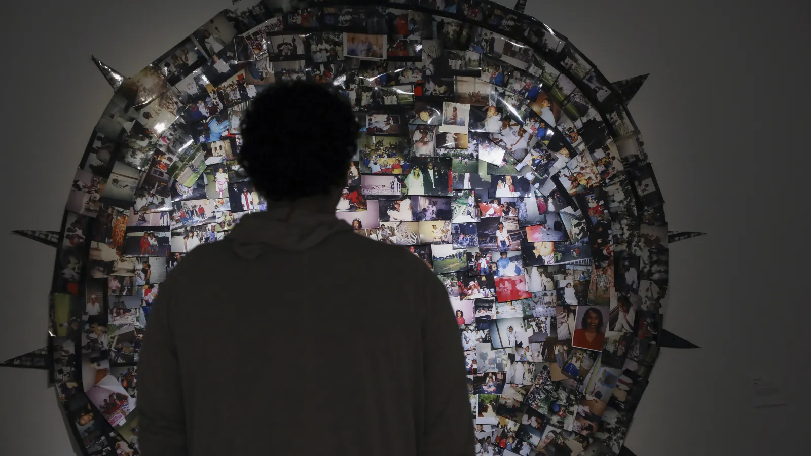 silhouette of a person standing in front of a photo collage