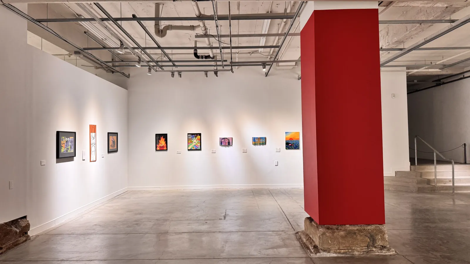 urban arts space gallery with a column painting red and artwork lining the walls