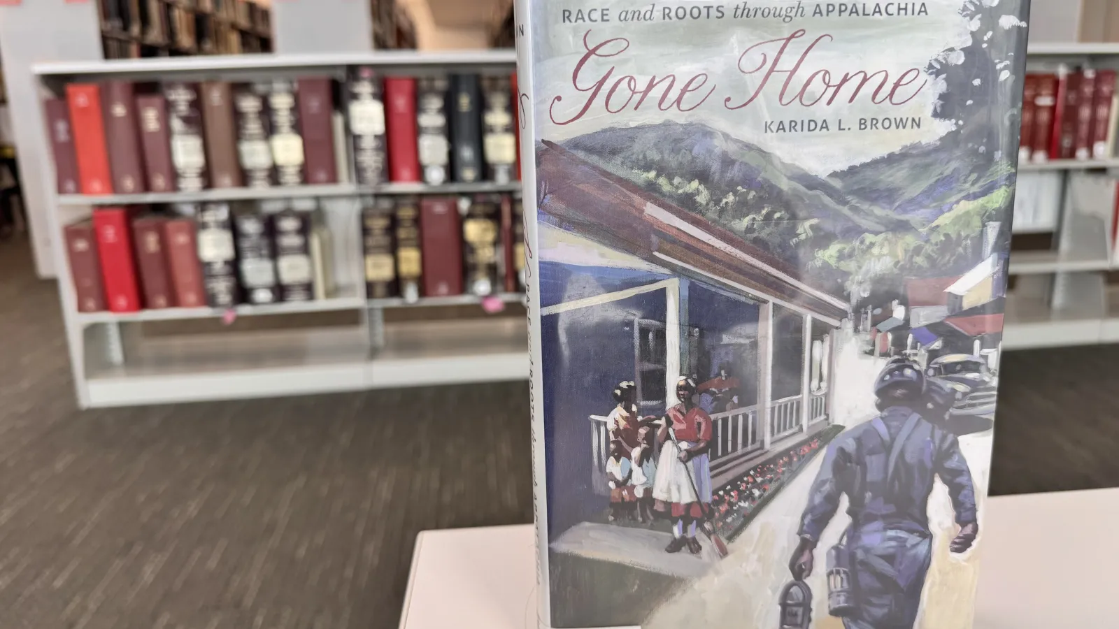 front cover of the book gone home by karida brown in a library setting