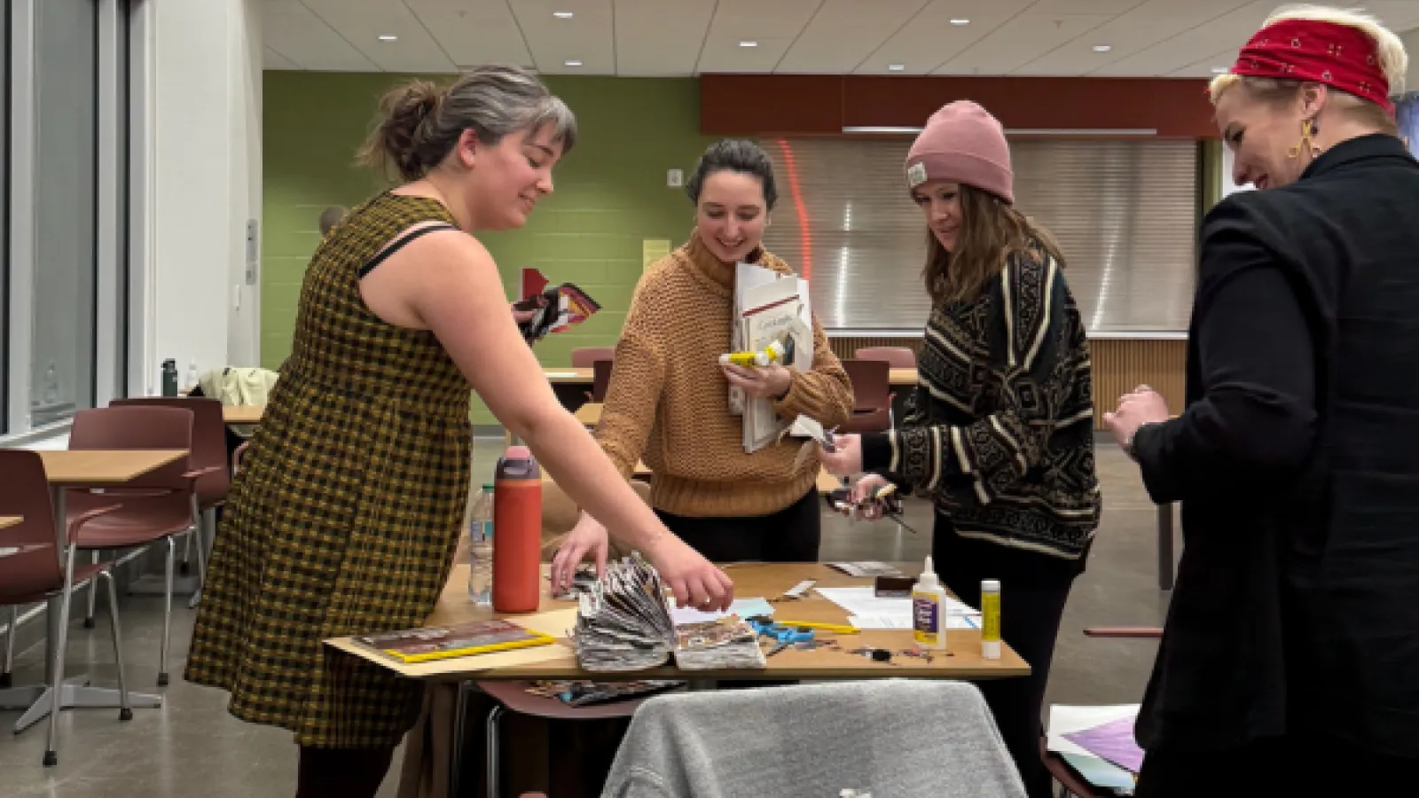 Emily Morgan and collage attendees smiling and selecting magazines