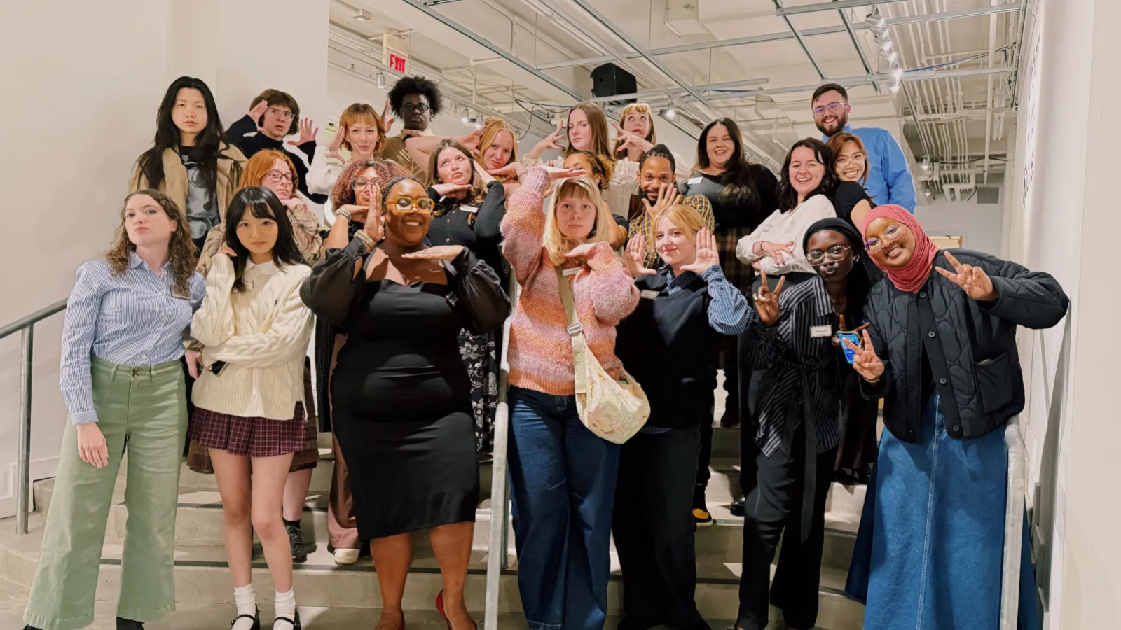 20+ urban arts space staff and interns posing on the gallery steps