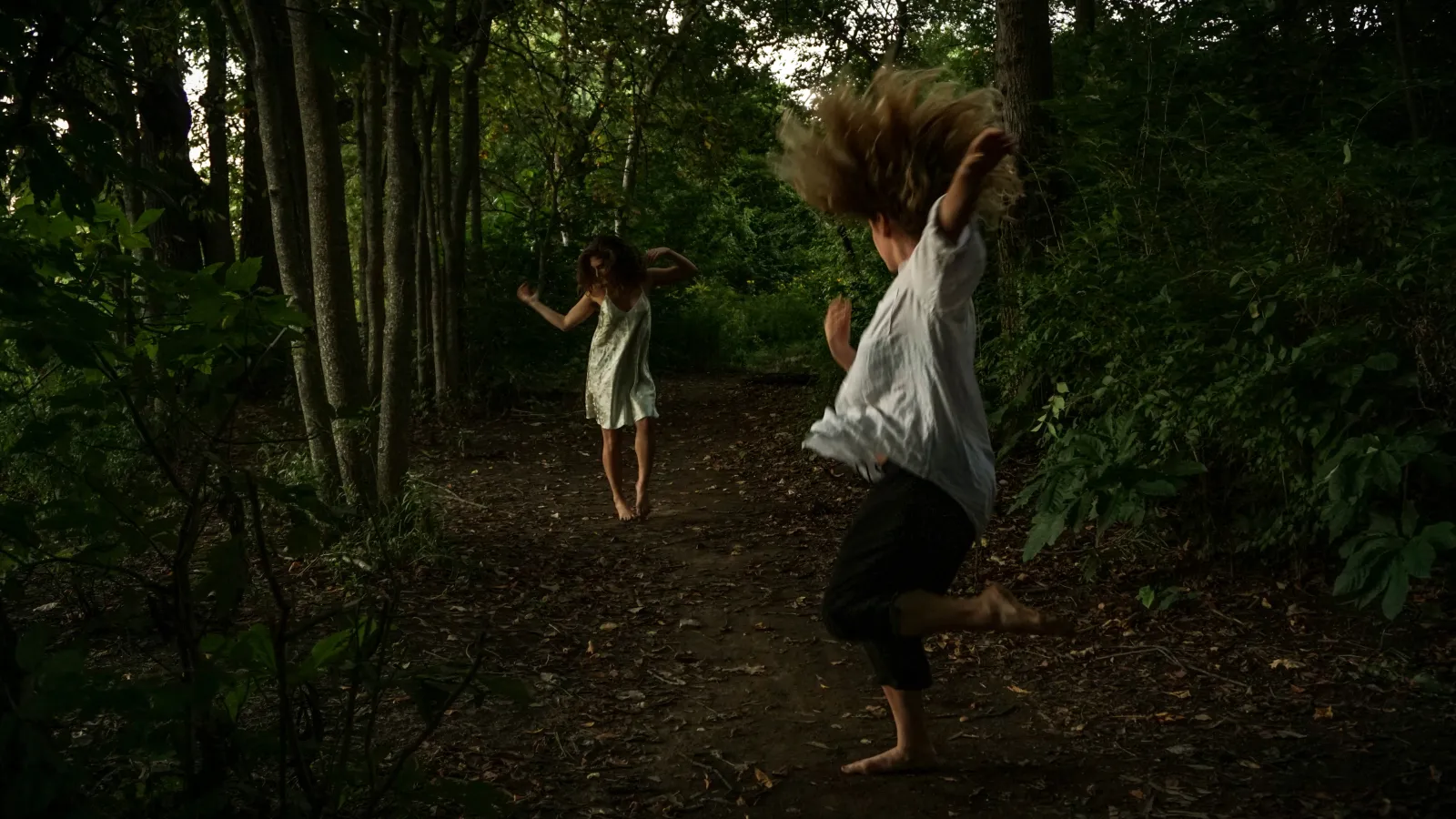 Two women dancing in a forest