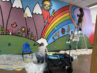 Arris' and Merijn working on a rainbow and mountain mural