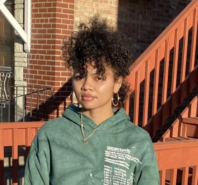 Photo of artist Iyana Hill in a green sweatshirt