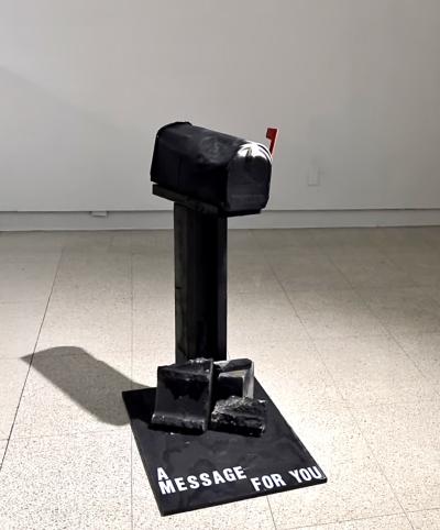 A black mailbox with text that says A Message for You