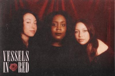 Three women in front of a red curtain with the text Vessels in Red
