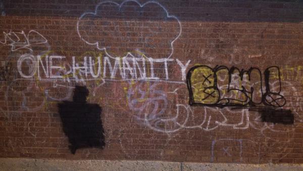 graffiti on brick wall that states, :one humanity" and "BLM"