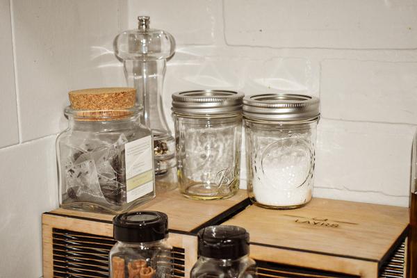 Various jars of ingredients sit on top of a LAYRS shelf stand.