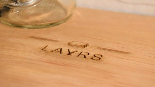 A close-up shot of the name LAYRS printed on the wooden shelf.