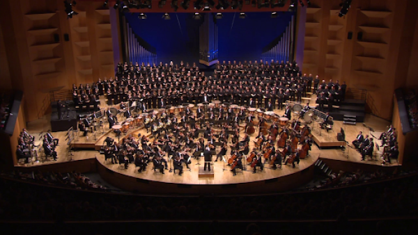 A large symphony and choir standing on a stage
