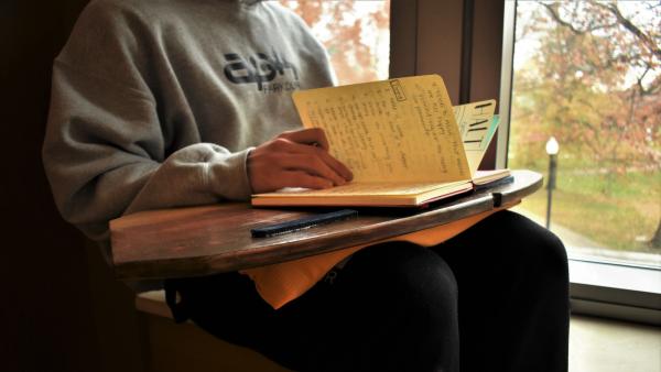 A model opens a book on top of their MANU Board.