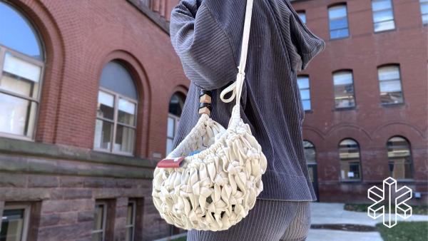 A person carries the Produce Cradle over their shoulder.