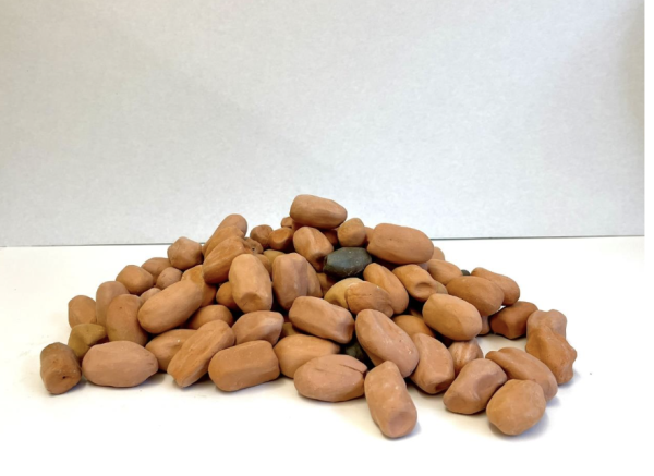 A pile of one hundred terracotta clay dates on a white pedestal
