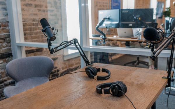 A desk and chair with microphones and headsets.