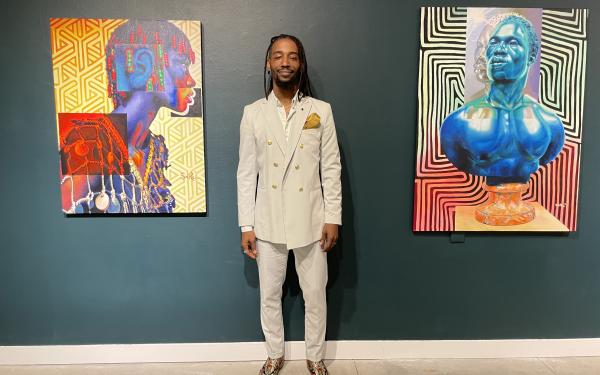 Arris' standing between two of his paintings