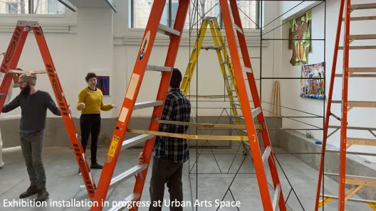 People installing an exhibition at Urban Arts Space.