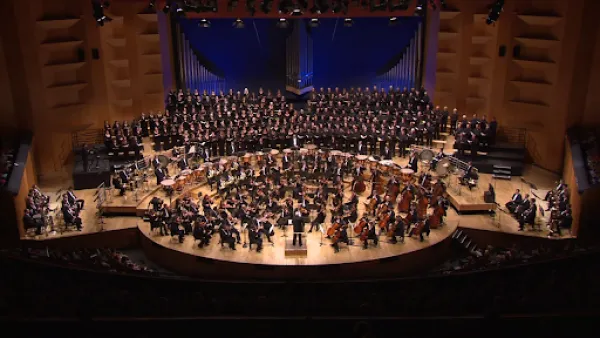 A large symphony and choir standing on a stage