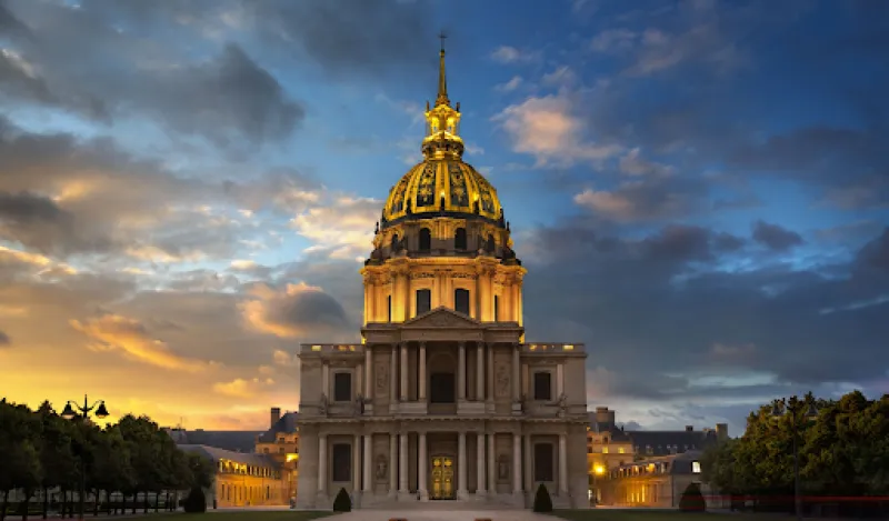 A large cathedral against a blue sky lit by golden sunlight