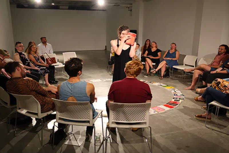 Visitors watching Michael J. Morris's interactive performance titled Bibliomancy.  