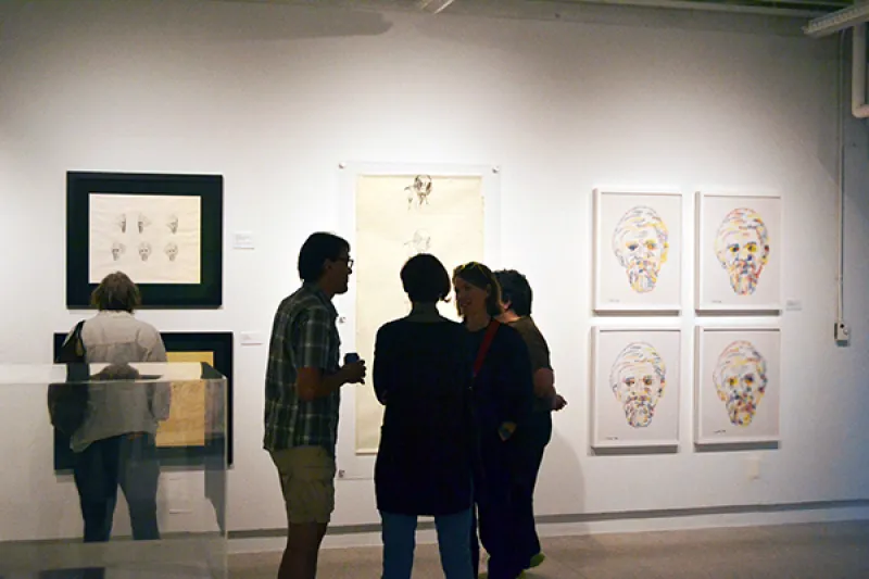 Three visitors conversing at the Charles Csuri Exhibition walkthrough.