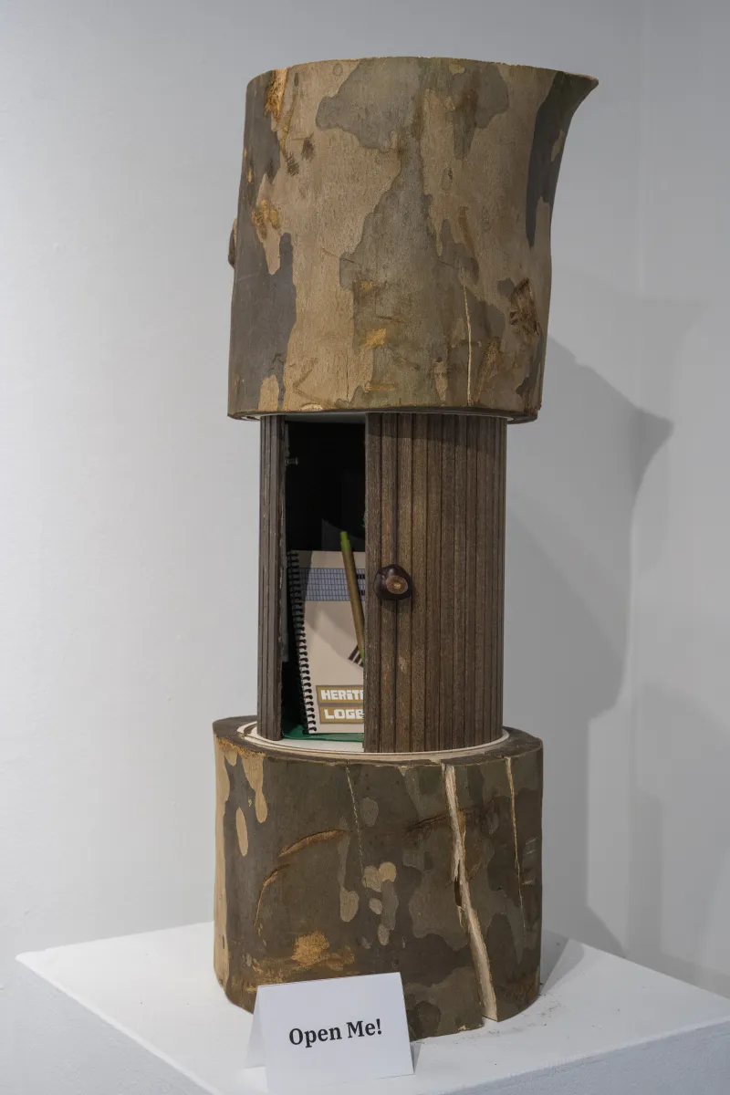 wooden container that looks like a tree trunk holds a notebook
