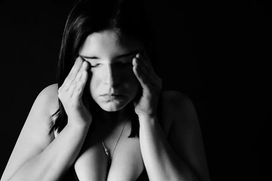 black and white image of woman holding face