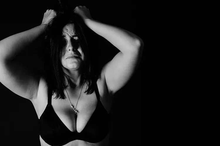 black and white image of woman holding face