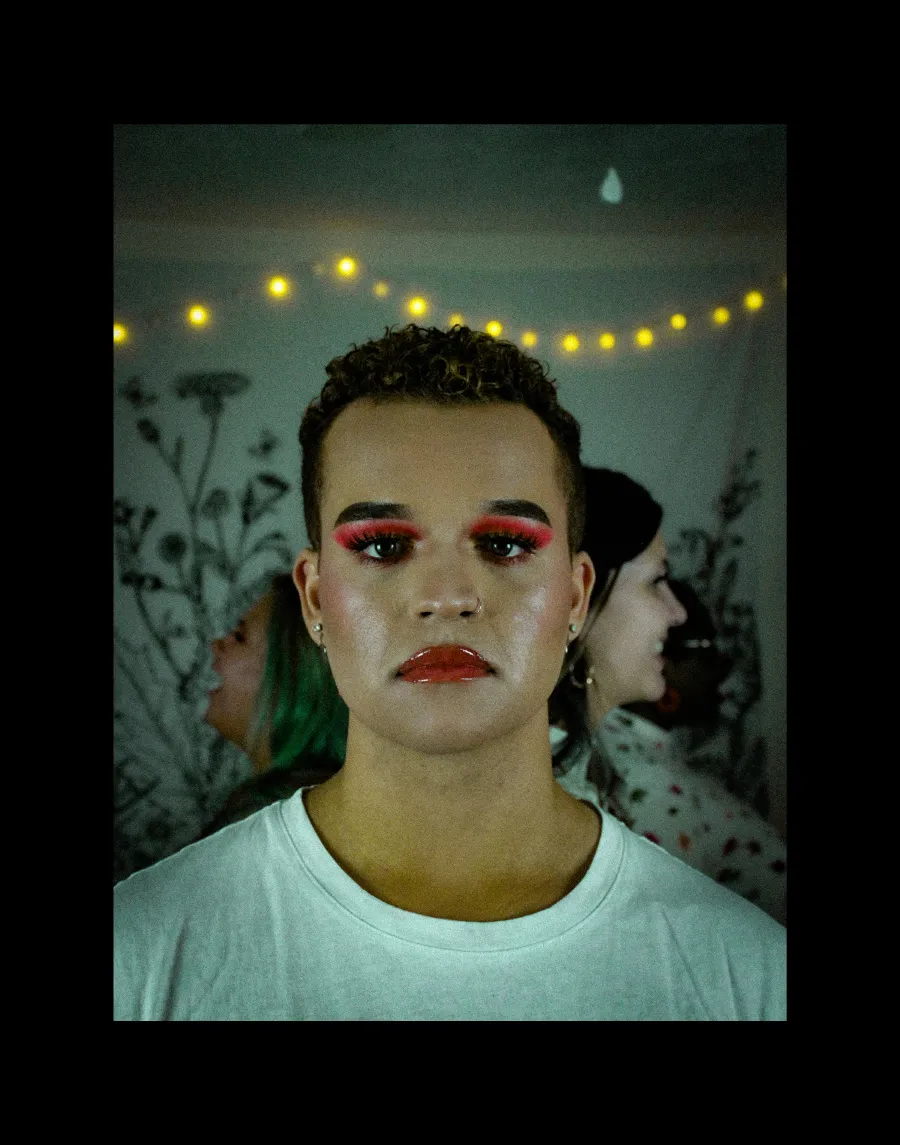 person with short hair wearing pink eyeshadow 