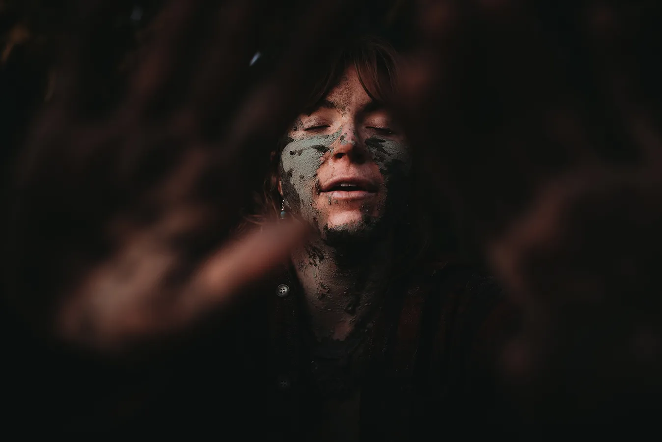 woman with mud on her face smiling