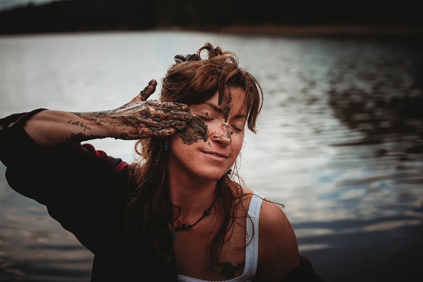 woman rubbing mud on her face