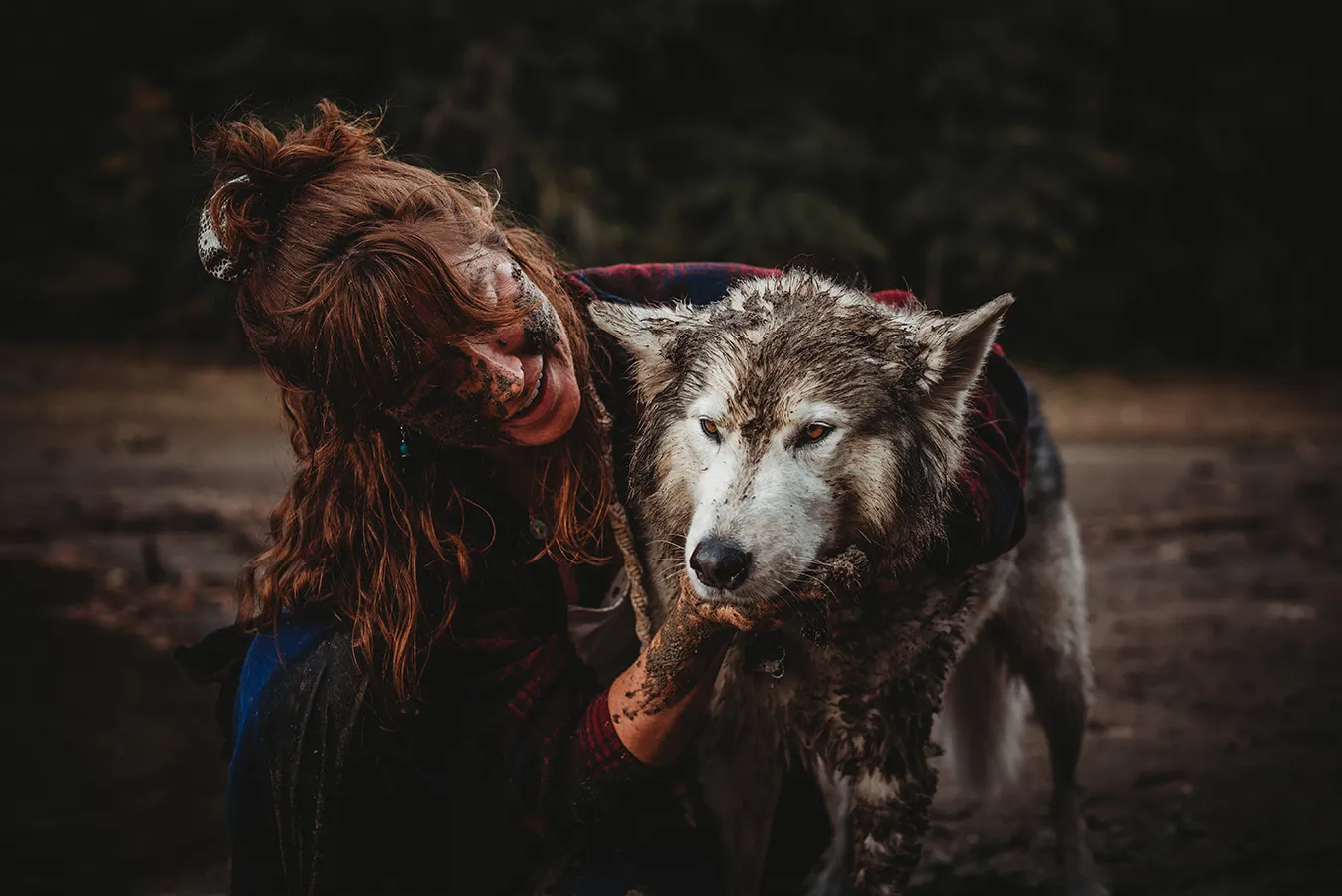woman and dog playing in mud
