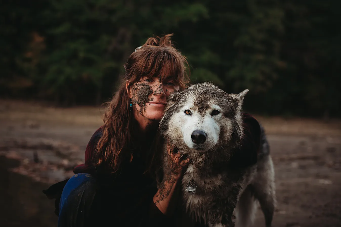 woman and dog playing in mud