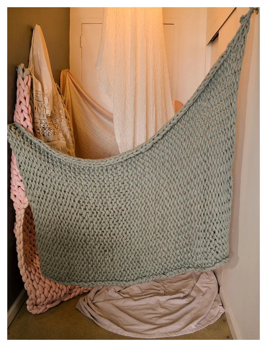 crocheted blanket hanging from wall
