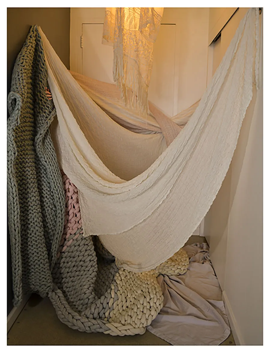 crocheted blanket hanging from wall