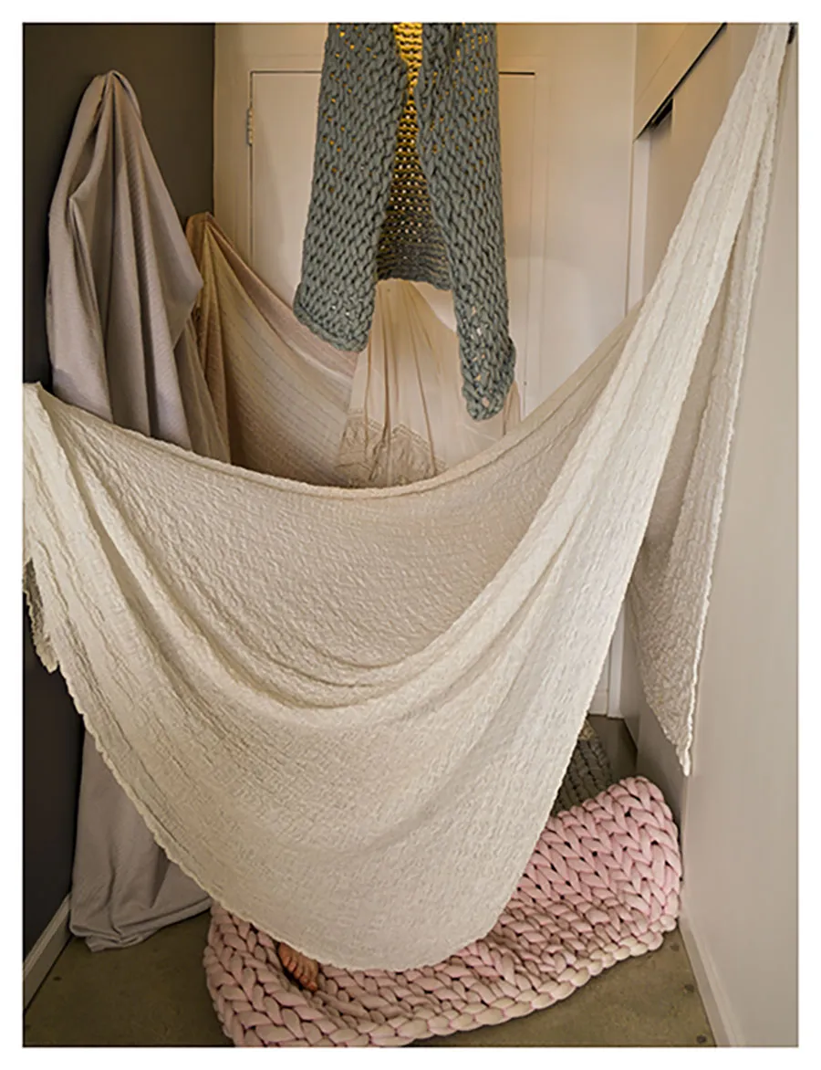 crocheted blankets hanging from wall