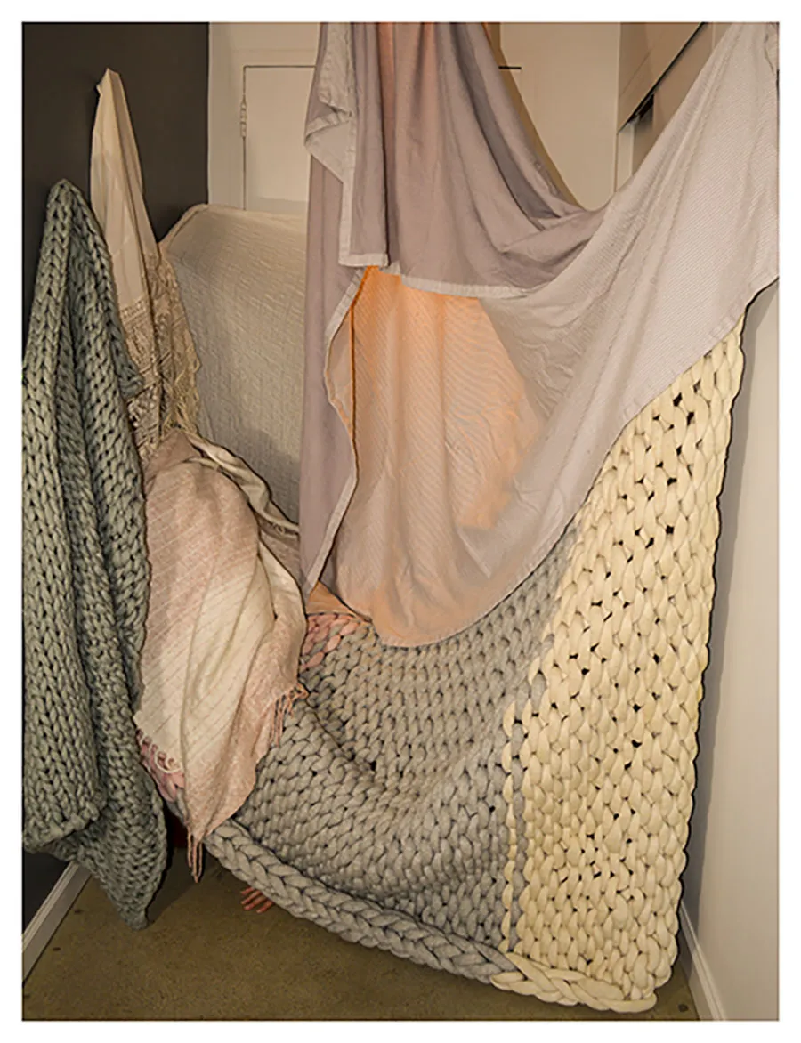 crocheted blankets hanging from wall