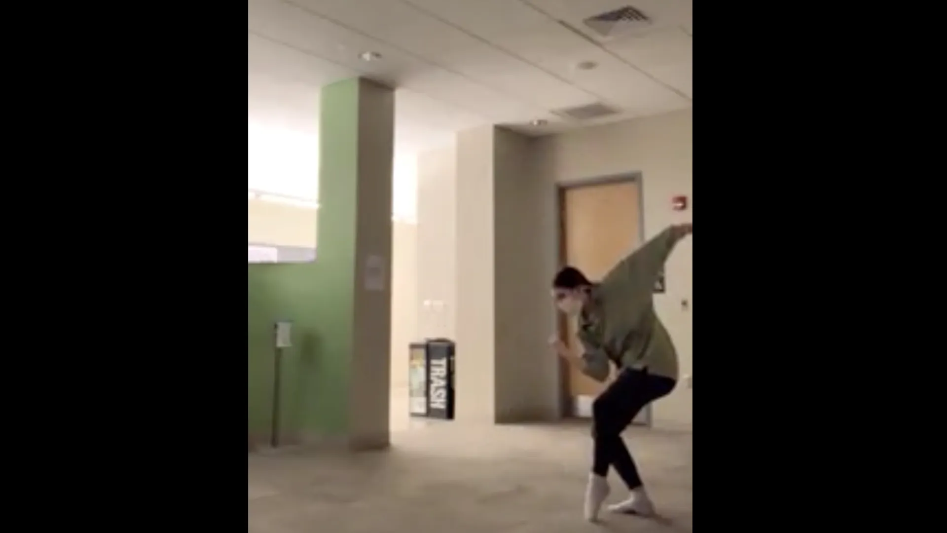 A dancer in front of a green column.
