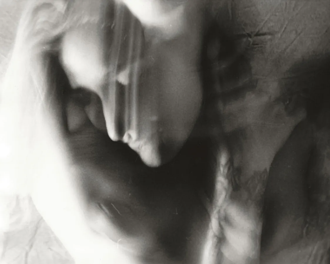A blurry black-and-white photo of a person with their head bent and eyes closed