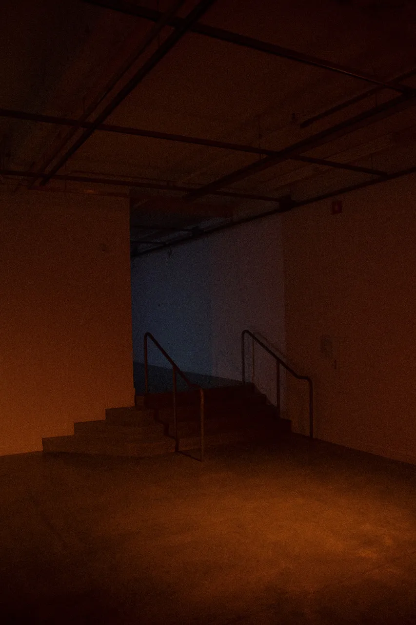 An empty gallery is dimly lit with an orange glow