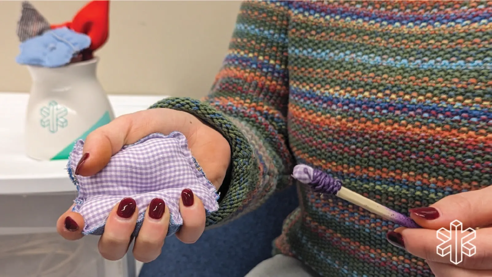 Person holding a small pillow and a stick
