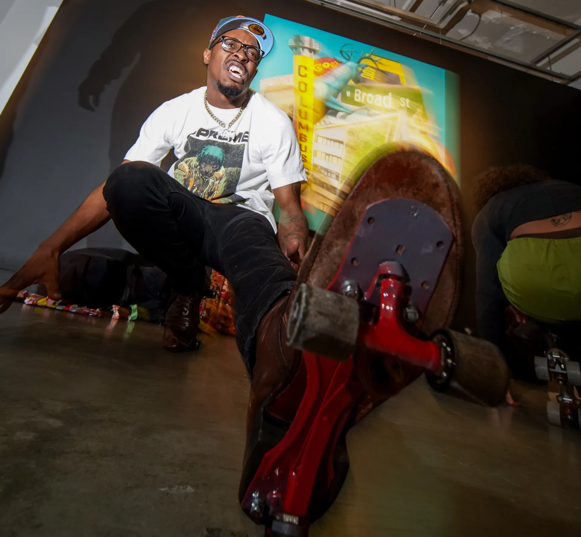 Picture of a man rollerskating in front of Arris' J. Cohen's work