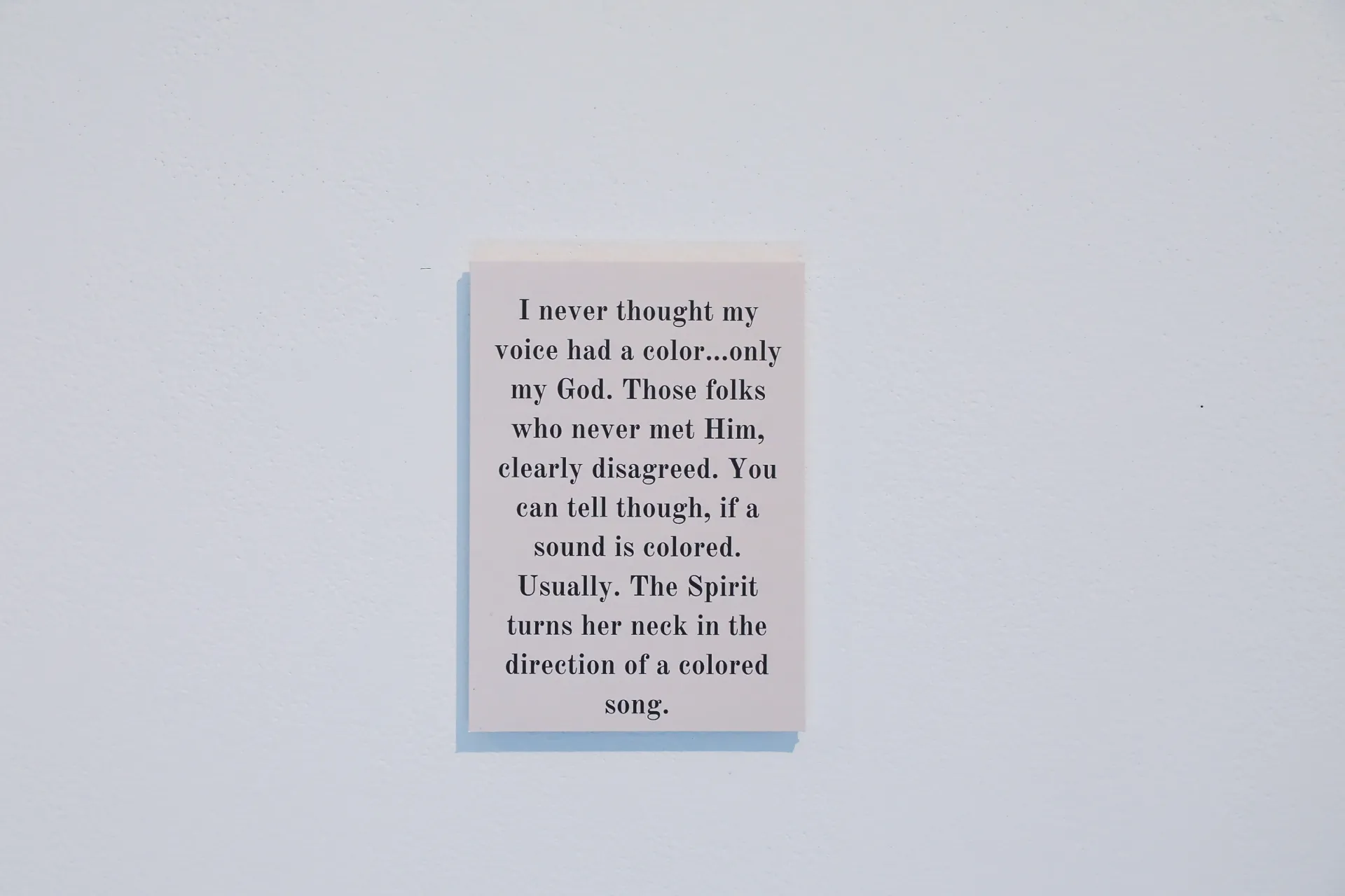 A poem on a light grey background. The poem says, “I never thought my voice had a color…only my God. Those folks who never met Him, clearly disagreed. You can tell though, if a sound is colored. Usually. The Spirit turns her neck in the direction of a colored song.”
