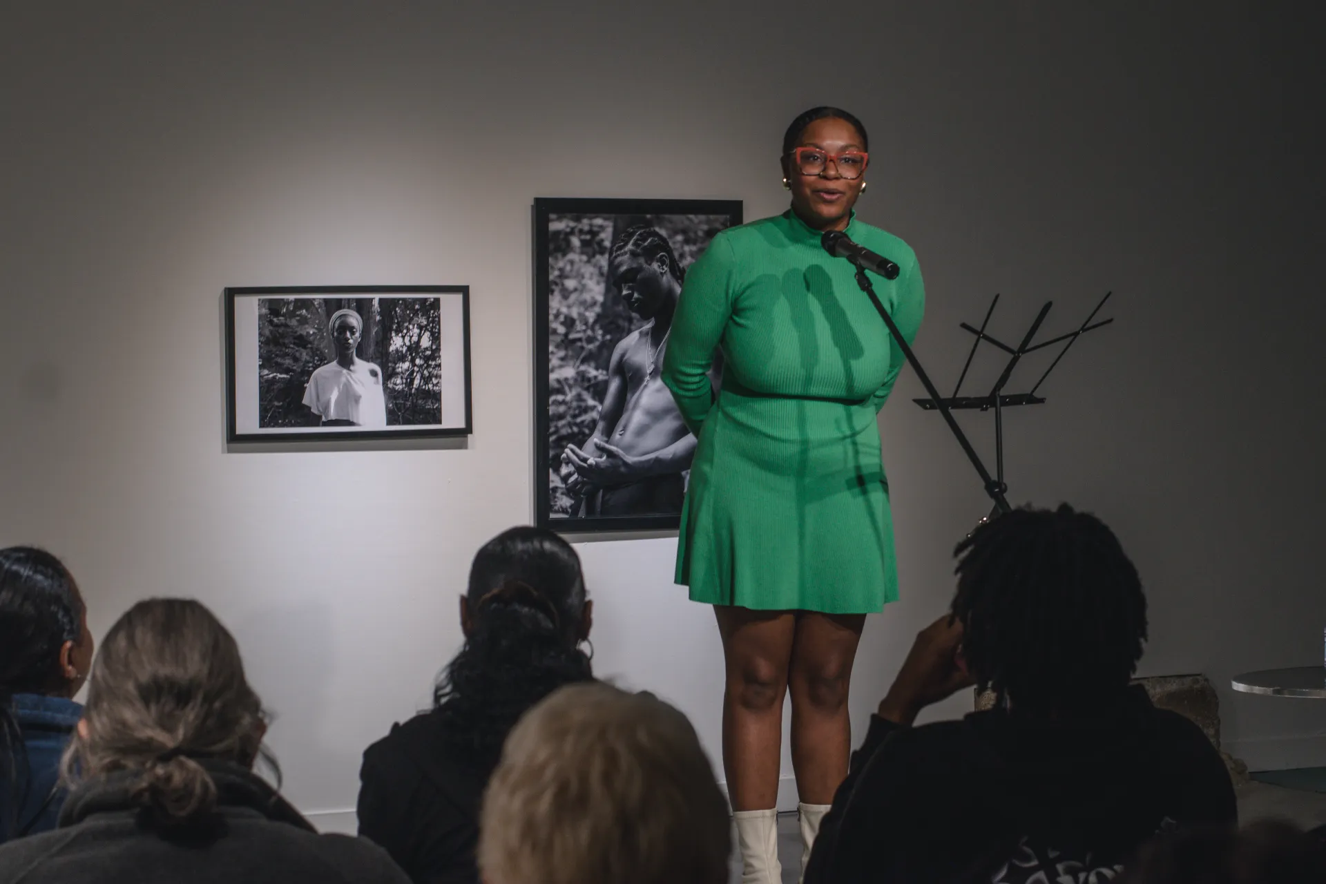 ajanae in a green dress reading poetry at the gallery