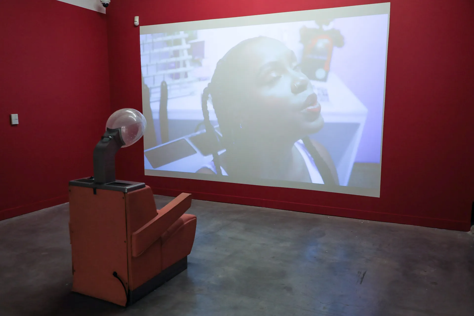 barber chair in front of a video fo ajanae reciting a poem as a martian on mars