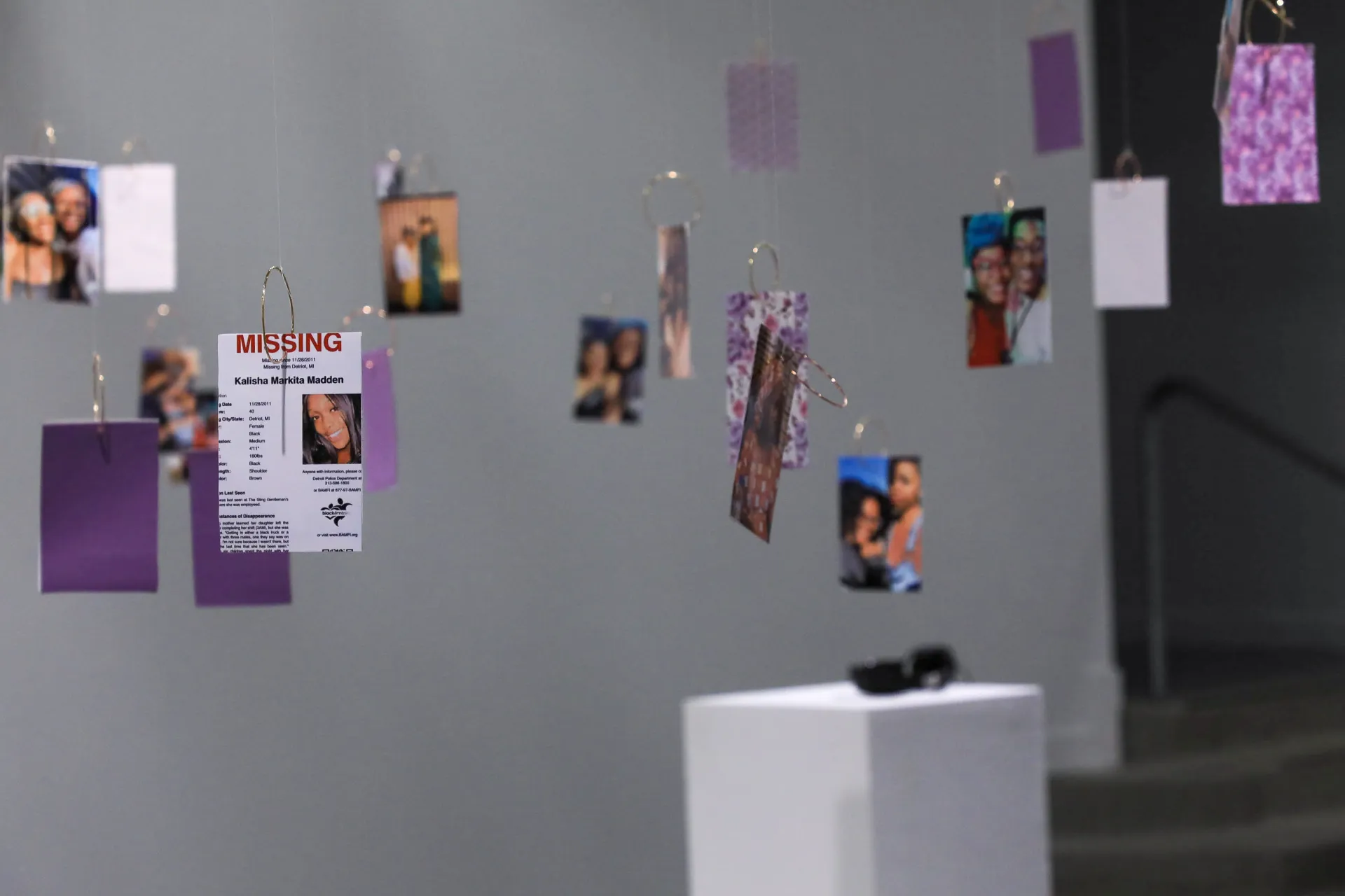 hanging photogrphs of black women, with one being a missing poster