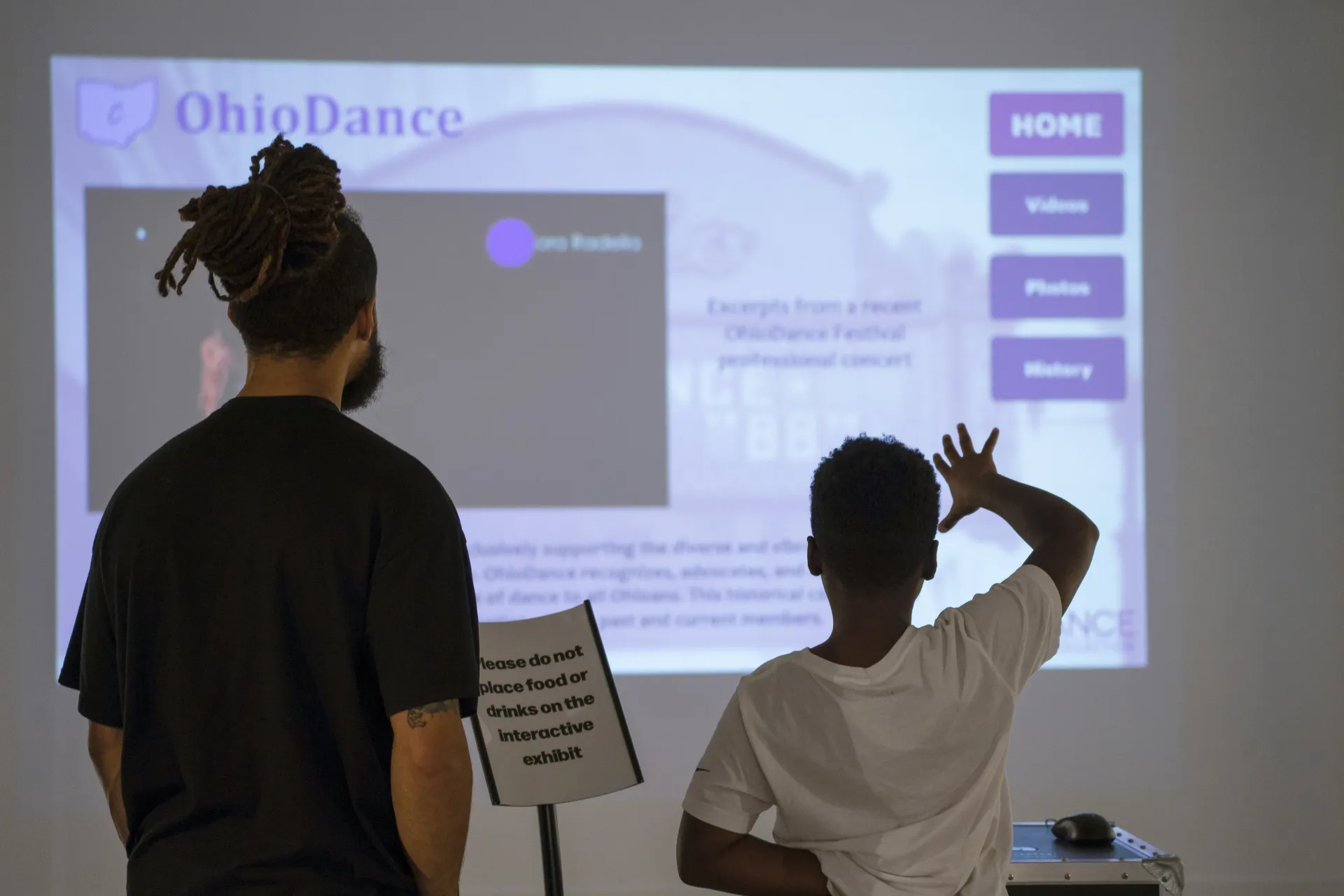 father and son using the touchless dance history interface